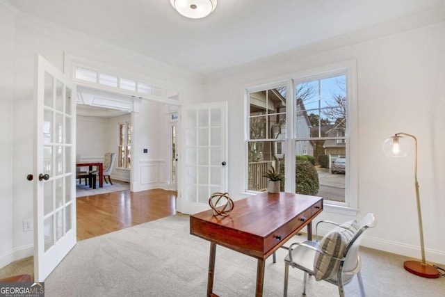 home office featuring crown molding, light hardwood / wood-style floors, and french doors