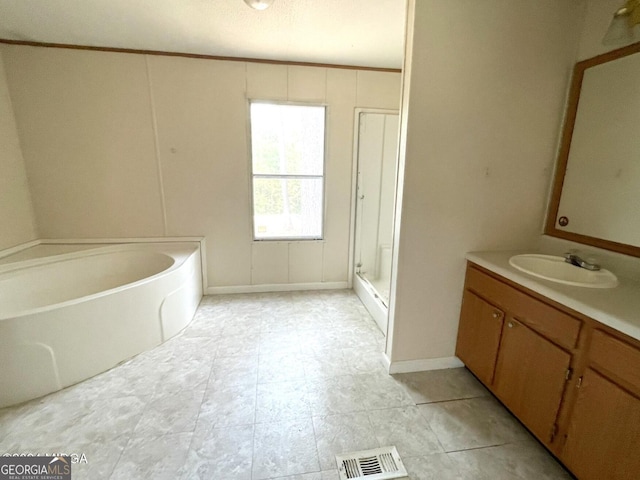 bathroom with vanity, ornamental molding, and a tub to relax in