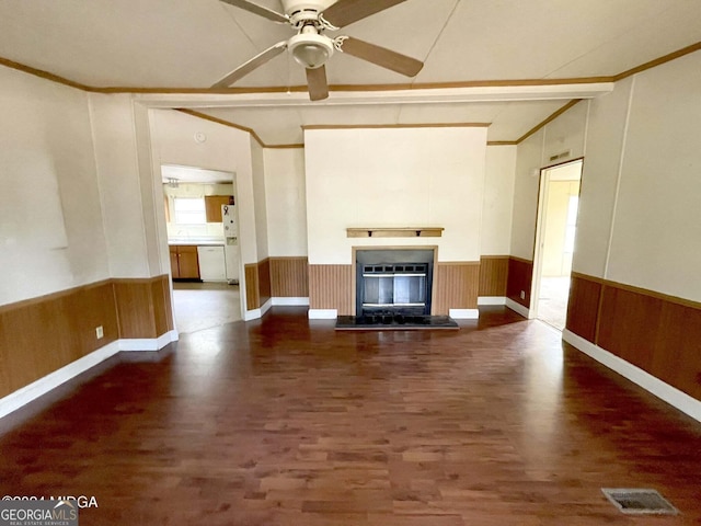 unfurnished living room with ornamental molding, dark hardwood / wood-style floors, ceiling fan, and wood walls