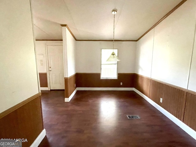 unfurnished dining area featuring crown molding and wooden walls