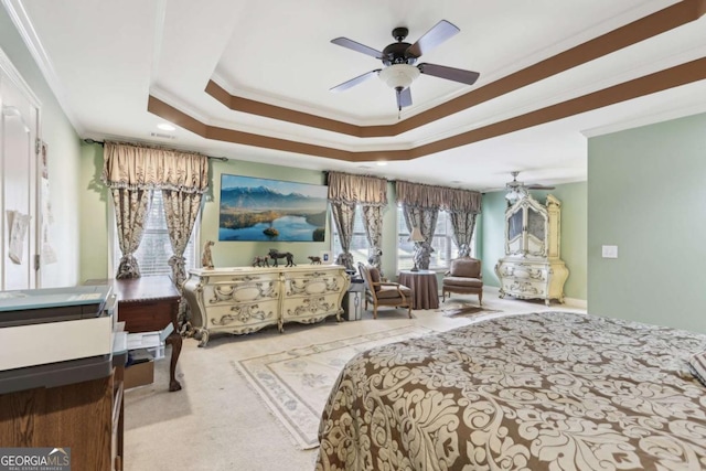 carpeted bedroom featuring ceiling fan, ornamental molding, and a tray ceiling