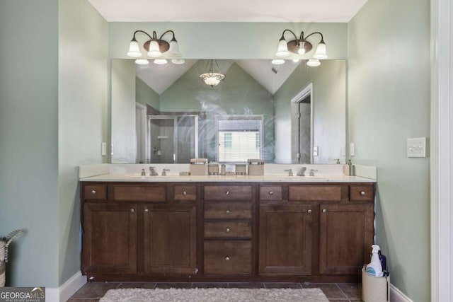 bathroom featuring lofted ceiling, vanity, a shower with shower door, and tile patterned floors