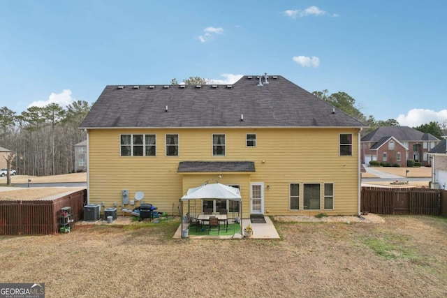 rear view of house featuring a patio, central AC unit, and a lawn