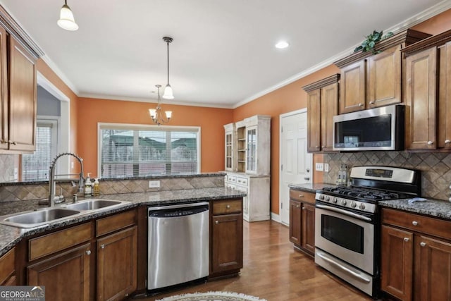 kitchen featuring ornamental molding, appliances with stainless steel finishes, sink, and pendant lighting