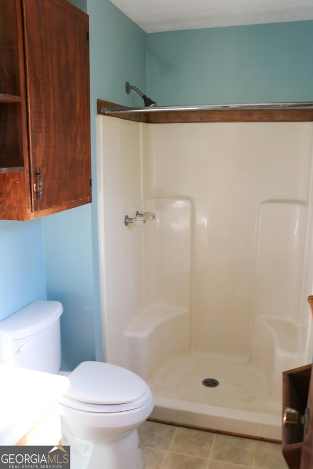 bathroom with vanity, tile patterned flooring, toilet, and walk in shower