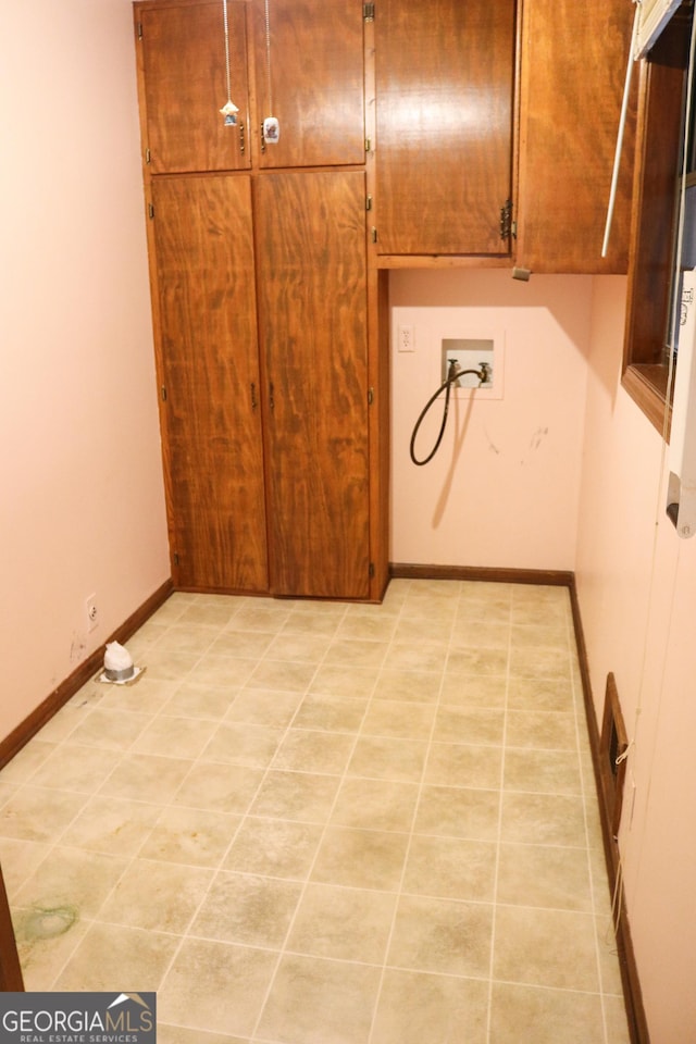laundry area with baseboards, cabinet space, light tile patterned floors, and washer hookup