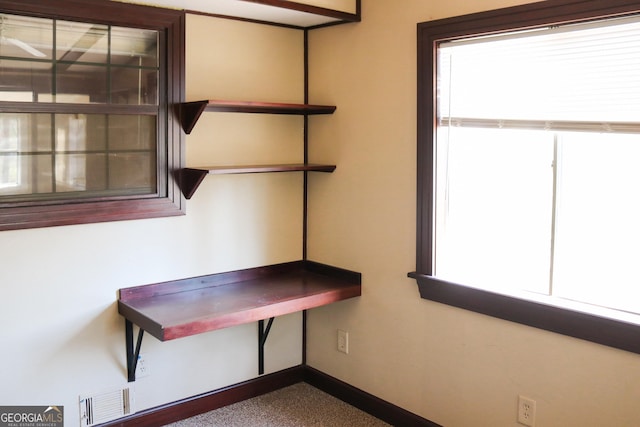 interior space featuring baseboards, carpet, and visible vents