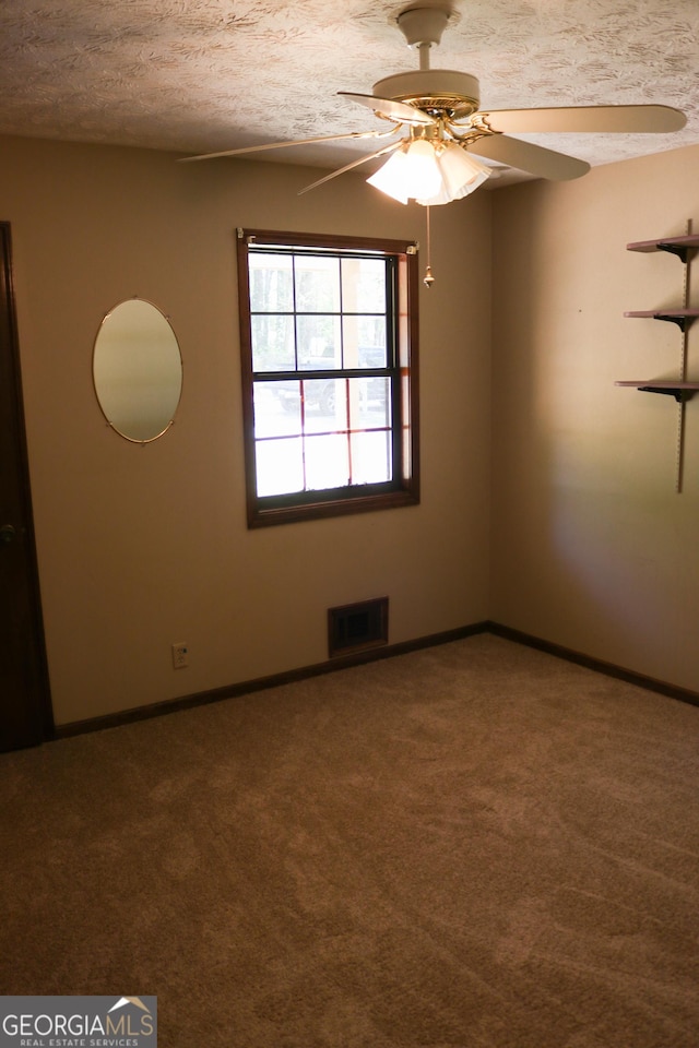 unfurnished room featuring carpet floors, a ceiling fan, baseboards, and visible vents