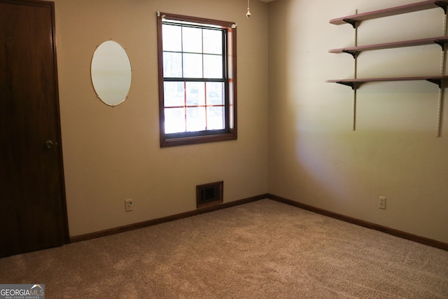 carpeted spare room featuring visible vents and baseboards