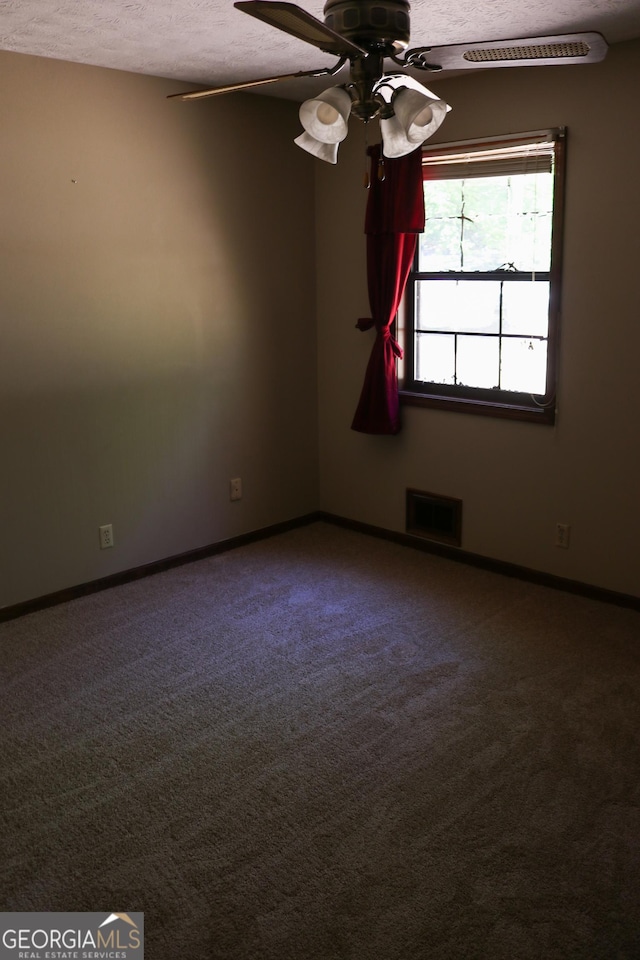carpeted spare room featuring visible vents, a ceiling fan, a textured ceiling, and baseboards