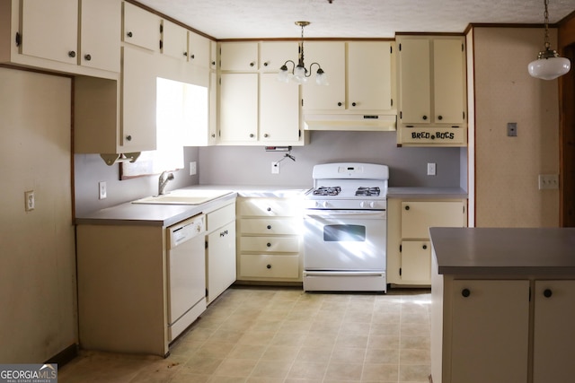 kitchen featuring decorative light fixtures, cream cabinets, a sink, under cabinet range hood, and white appliances