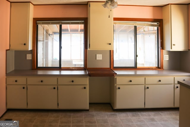 kitchen featuring a healthy amount of sunlight, cream cabinets, light tile patterned flooring, and ceiling fan