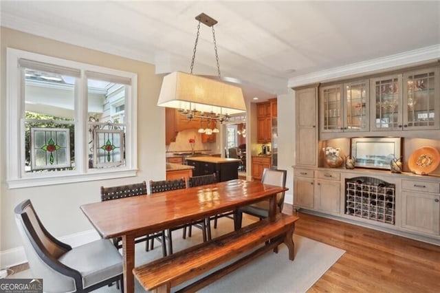 dining area with crown molding and light hardwood / wood-style flooring