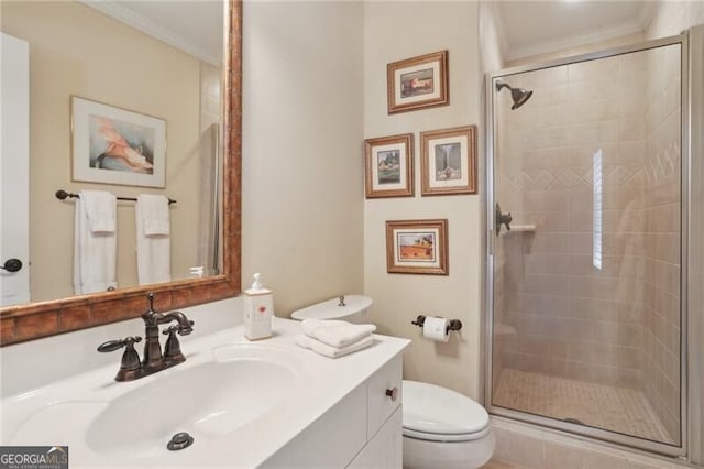 bathroom featuring vanity, a shower with shower door, ornamental molding, and toilet