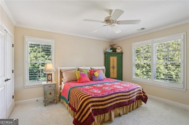 carpeted bedroom with ornamental molding and ceiling fan