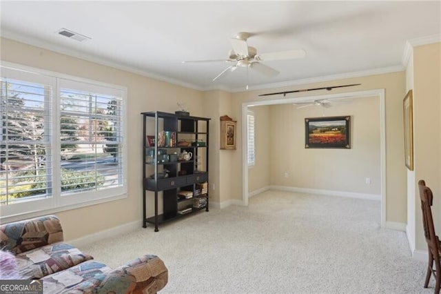 sitting room with ornamental molding, a healthy amount of sunlight, and light colored carpet