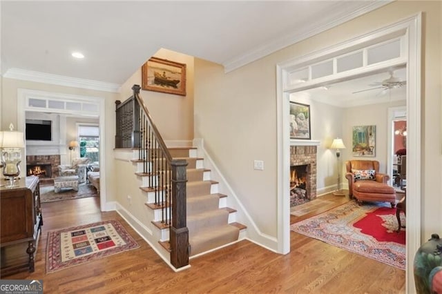 stairway with crown molding, ceiling fan, and hardwood / wood-style floors