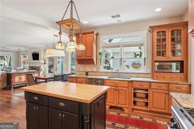 kitchen featuring sink, hanging light fixtures, dark hardwood / wood-style floors, a kitchen island, and stainless steel appliances