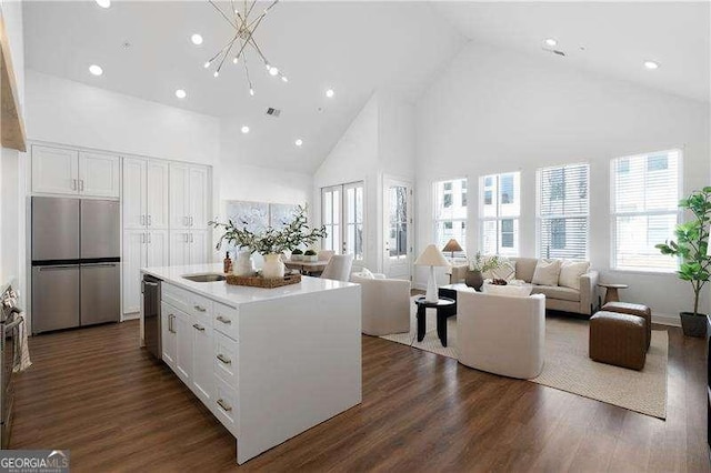 kitchen with dark wood-type flooring, stainless steel appliances, a center island, and white cabinets