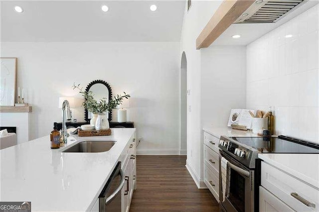 kitchen with sink, white cabinetry, dark hardwood / wood-style floors, stainless steel appliances, and backsplash