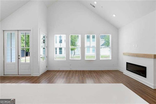 unfurnished living room featuring hardwood / wood-style flooring and high vaulted ceiling