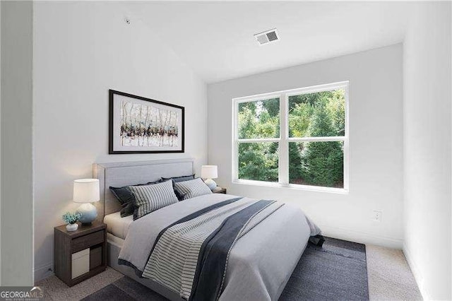 carpeted bedroom with vaulted ceiling