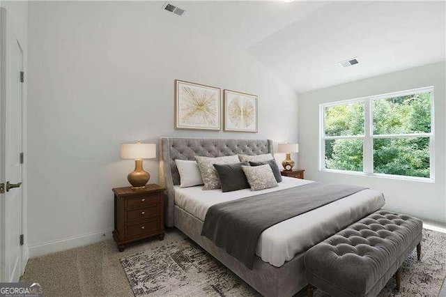 bedroom with vaulted ceiling and light colored carpet