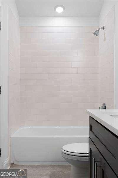 full bathroom featuring vanity, toilet, and tiled shower / bath combo