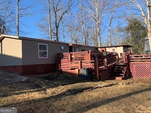 rear view of house with a deck and a lawn