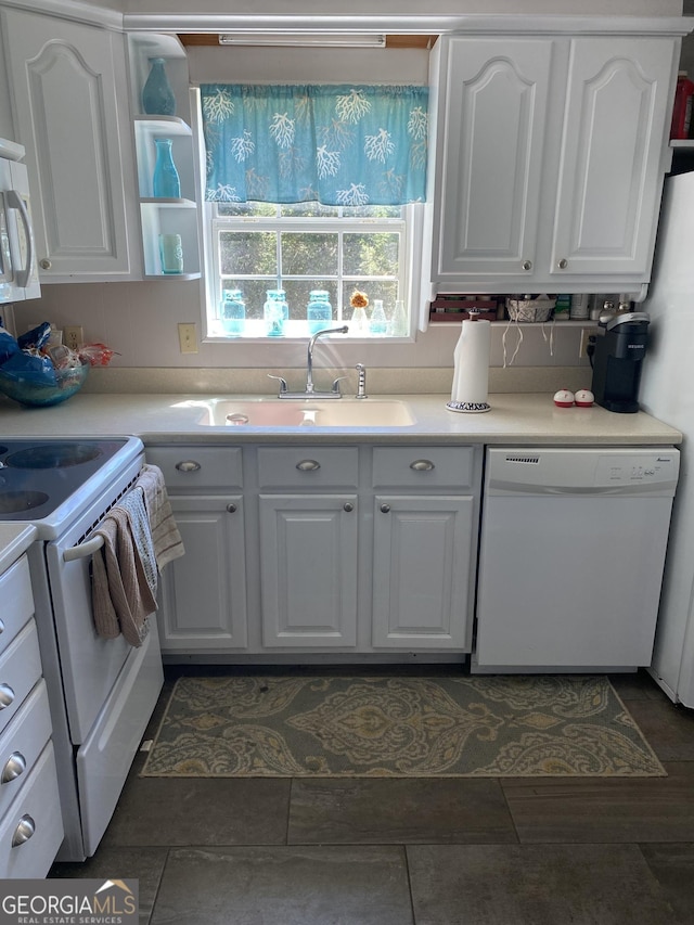 kitchen featuring white cabinets, white appliances, light countertops, and a sink
