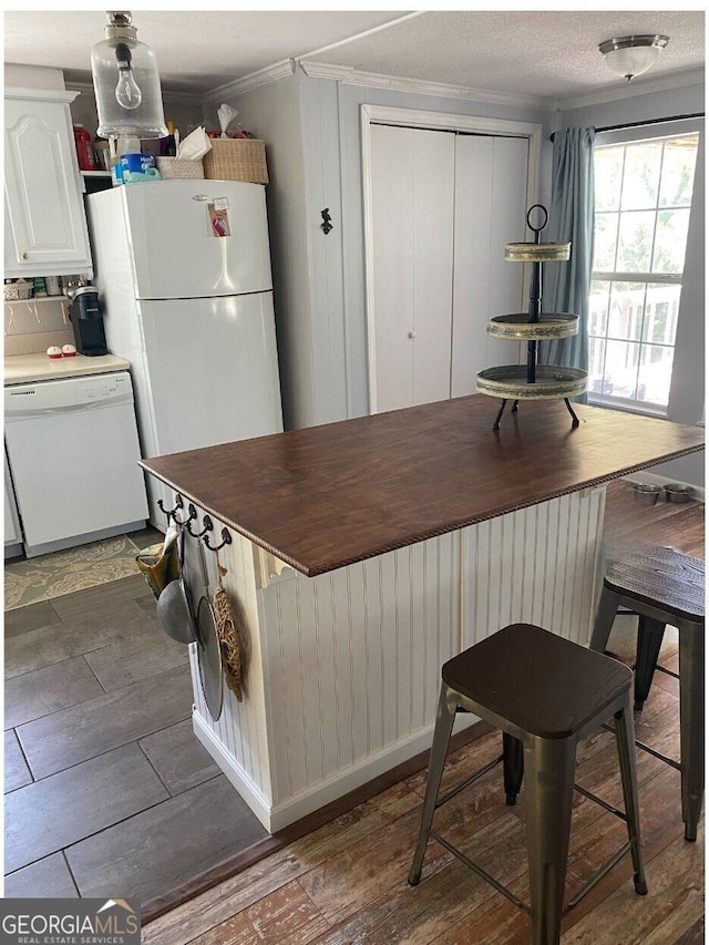 kitchen featuring crown molding, dark wood finished floors, radiator heating unit, white cabinets, and white appliances
