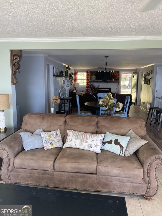living area with a fireplace, a textured ceiling, and crown molding