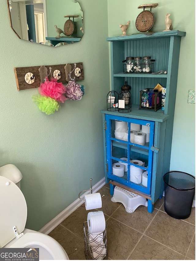 bathroom featuring tile patterned flooring, toilet, and baseboards