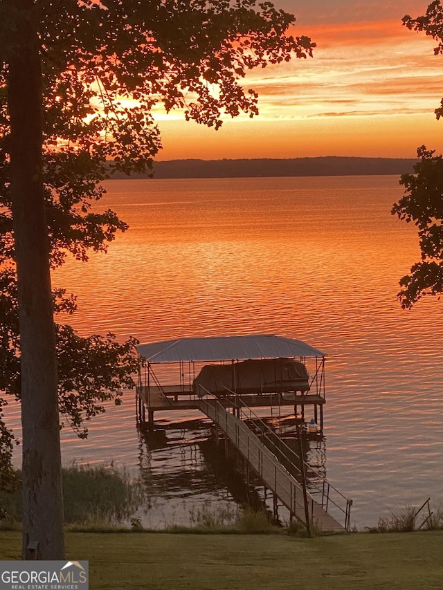 dock area with boat lift and a water view