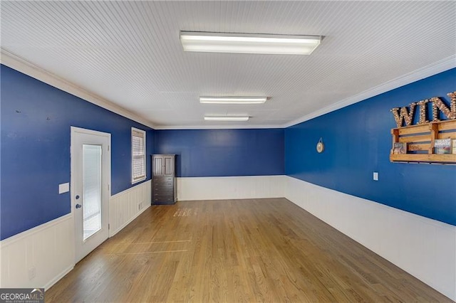 spare room featuring crown molding and light hardwood / wood-style flooring