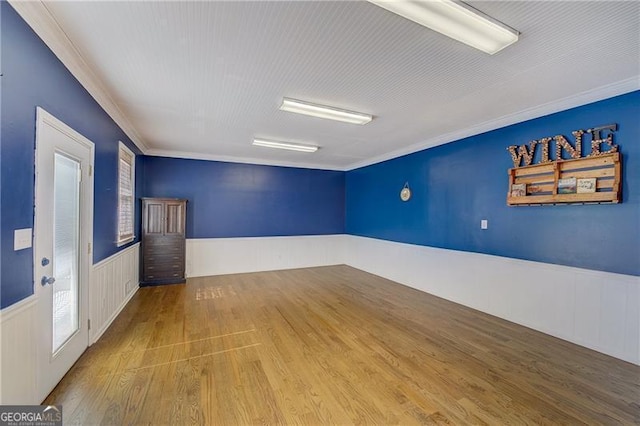 empty room with wood-type flooring and ornamental molding