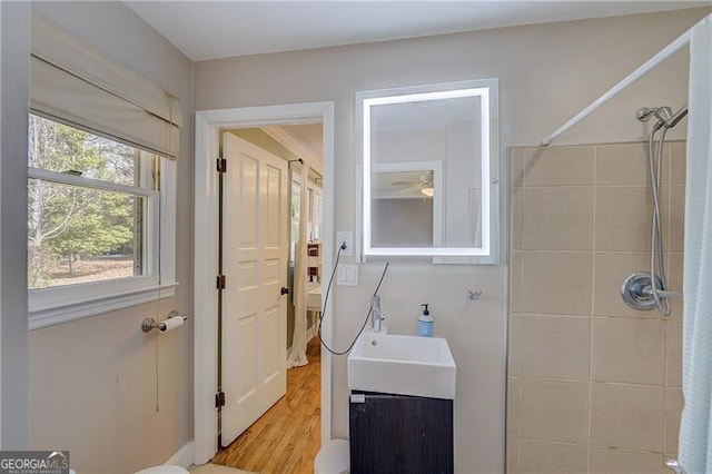 bathroom featuring vanity, hardwood / wood-style flooring, and tiled shower