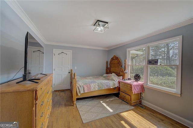 bedroom with ornamental molding and light wood-type flooring