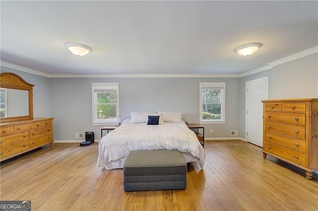 bedroom with ornamental molding and light hardwood / wood-style floors