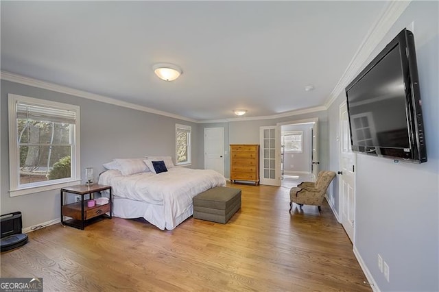 bedroom with crown molding and light hardwood / wood-style flooring