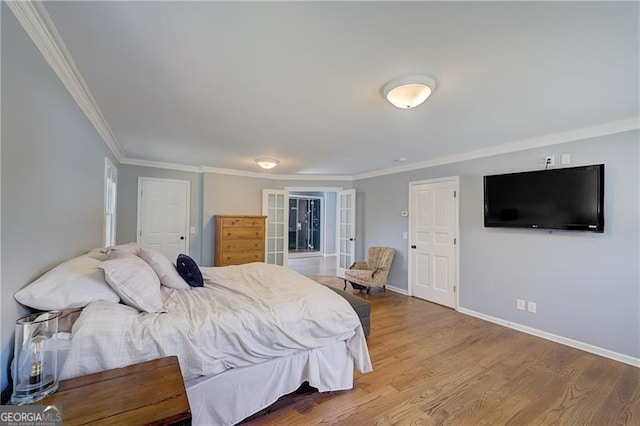 bedroom featuring hardwood / wood-style flooring, ornamental molding, and french doors