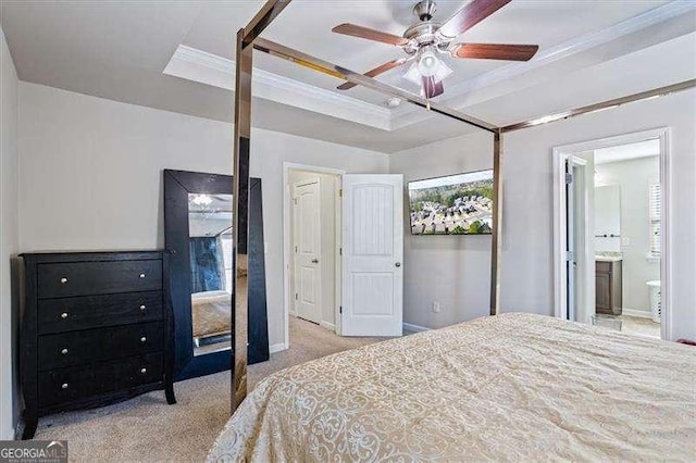 carpeted bedroom with crown molding, ensuite bath, a raised ceiling, and ceiling fan