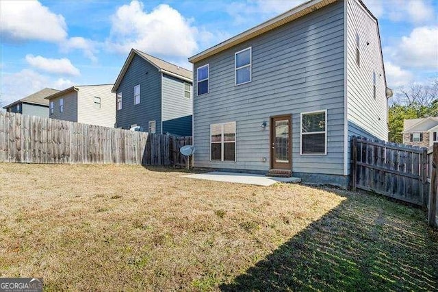 back of house featuring a patio and a lawn