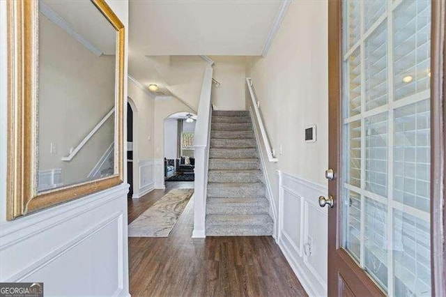 foyer entrance with crown molding and dark hardwood / wood-style floors