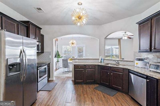 kitchen with stainless steel appliances, sink, pendant lighting, and a notable chandelier