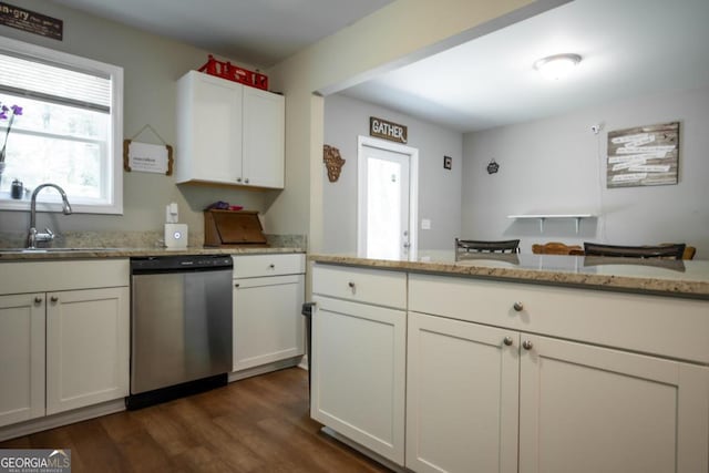 kitchen with dark hardwood / wood-style floors, sink, white cabinets, stainless steel dishwasher, and light stone counters