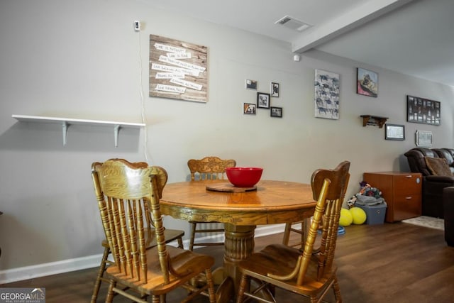 dining room with dark hardwood / wood-style floors and beam ceiling