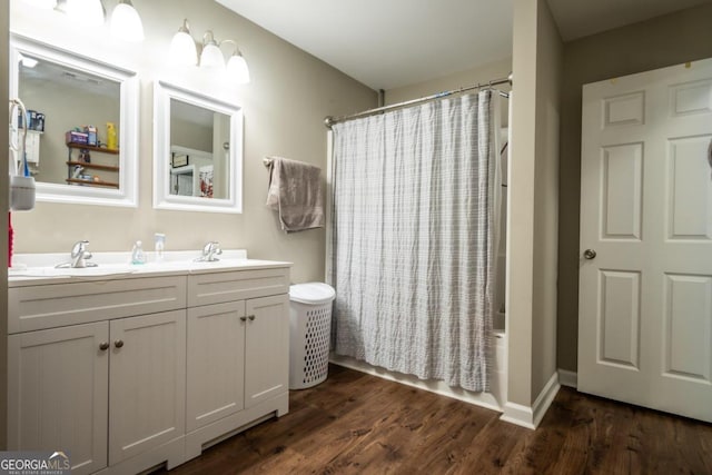 bathroom with hardwood / wood-style flooring, vanity, and shower / bathtub combination with curtain