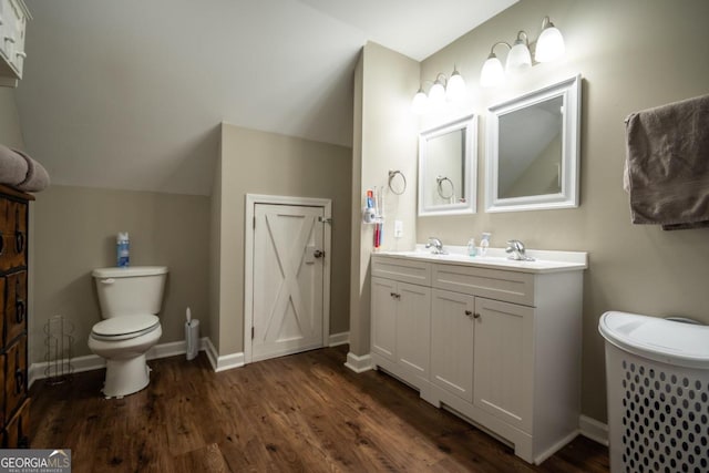 bathroom featuring lofted ceiling, vanity, hardwood / wood-style flooring, and toilet