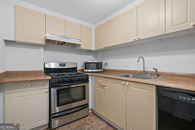 kitchen with stainless steel appliances, cream cabinets, and sink